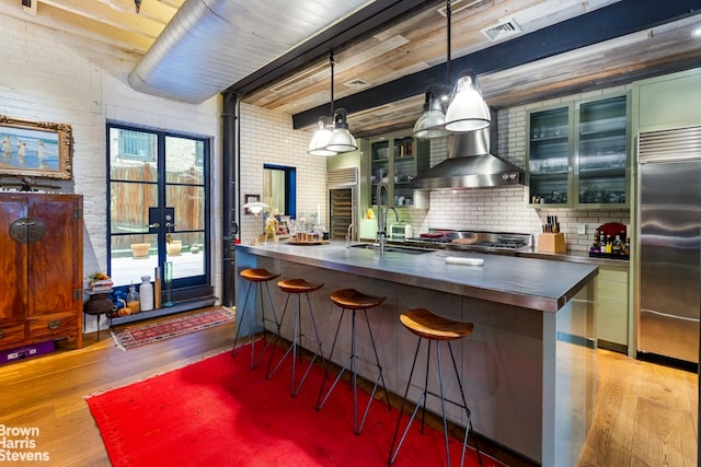 kitchen with beam ceiling, stainless steel countertops, visible vents, appliances with stainless steel finishes, and wood finished floors