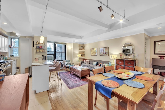 dining space featuring a raised ceiling, light wood-style flooring, crown molding, track lighting, and recessed lighting