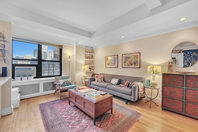 living area featuring light wood-type flooring, cooling unit, a tray ceiling, and a city view