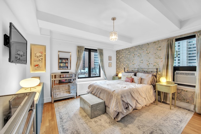 227 E 57th St Unit 9Fg, New York City, NY 10022 - bedroom with cooling unit, an accent wall, wood finished floors, baseboards, and wallpapered walls