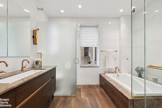 37 W 93rd St Unit 17/13, New York City, NY 10025 - bathroom featuring vanity, a bath, wood finished floors, a shower stall, and tile walls