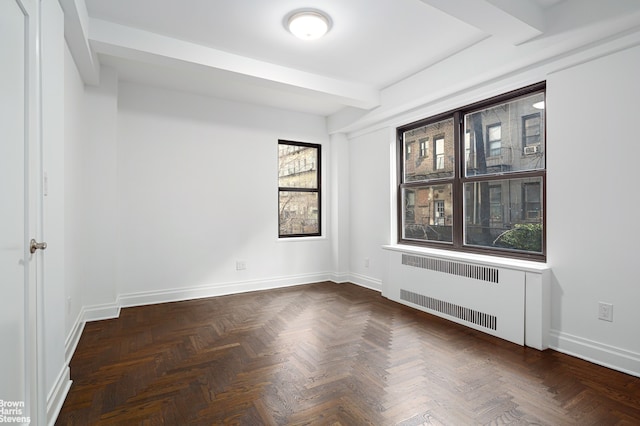 spare room with radiator heating unit, baseboards, and beamed ceiling