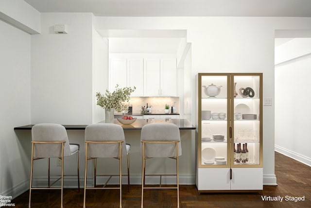 kitchen with baseboards, white cabinets, and decorative backsplash