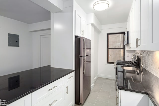 kitchen with appliances with stainless steel finishes, backsplash, electric panel, and white cabinets