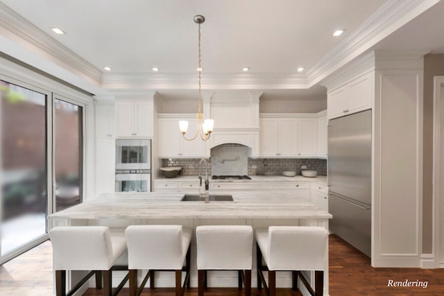 kitchen with a chandelier, stainless steel appliances, a sink, white cabinetry, and pendant lighting