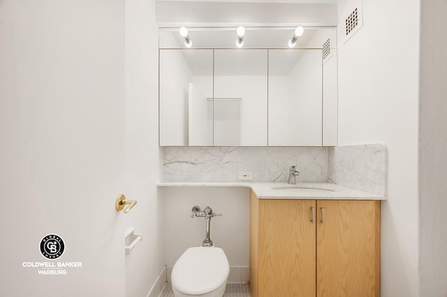 200 E 57th St Unit 9G, New York City, NY 10022 - bathroom with toilet, vanity, decorative backsplash, and baseboards