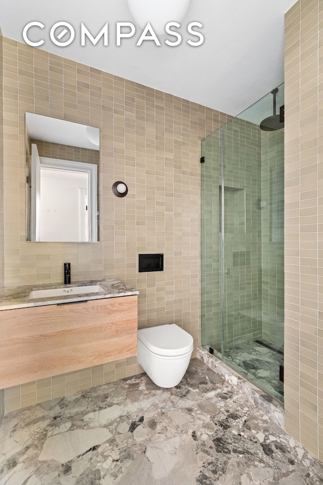 bathroom featuring a shower stall, tile walls, vanity, and toilet