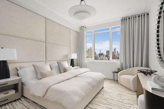 bedroom featuring light wood-style floors and a city view