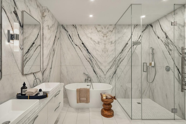 bathroom featuring a freestanding bath, double vanity, a sink, and a marble finish shower