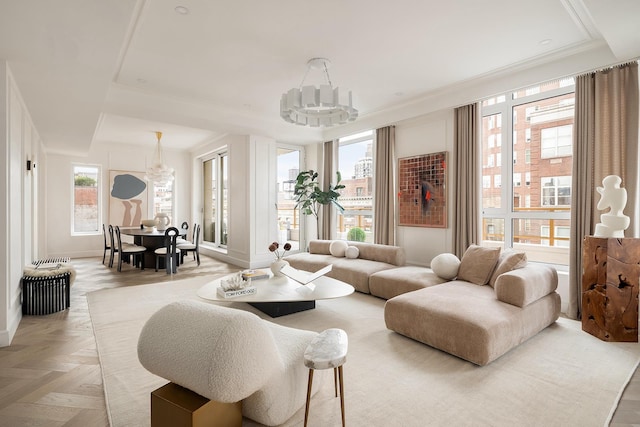 living area featuring ornamental molding, a notable chandelier, and baseboards