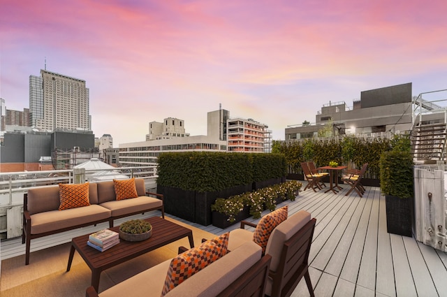 deck at dusk featuring a view of city and outdoor lounge area