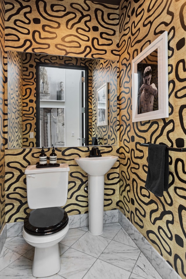 bathroom featuring toilet and marble finish floor