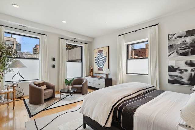 bedroom with light wood finished floors, multiple windows, visible vents, and recessed lighting