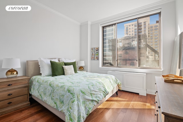 bedroom with ornamental molding, visible vents, and wood finished floors