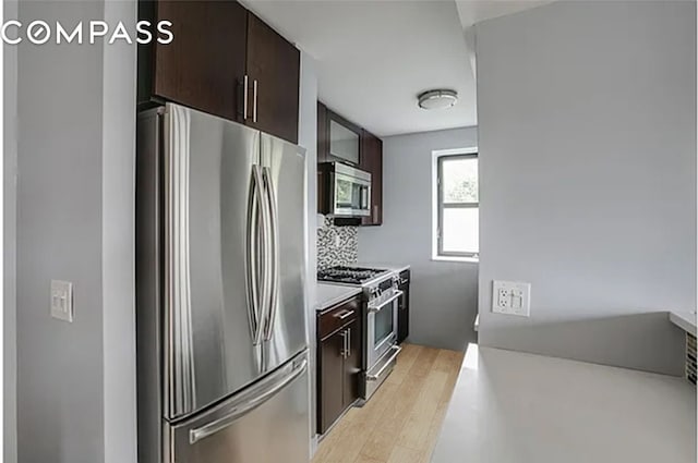 kitchen with stainless steel appliances, light wood finished floors, light countertops, and dark brown cabinetry