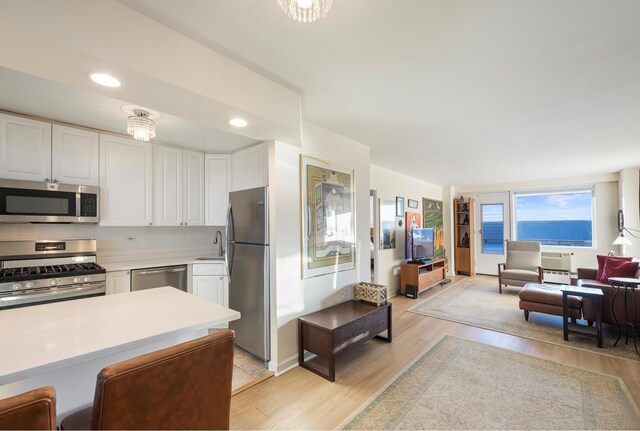 kitchen featuring a peninsula, white cabinetry, appliances with stainless steel finishes, and light countertops