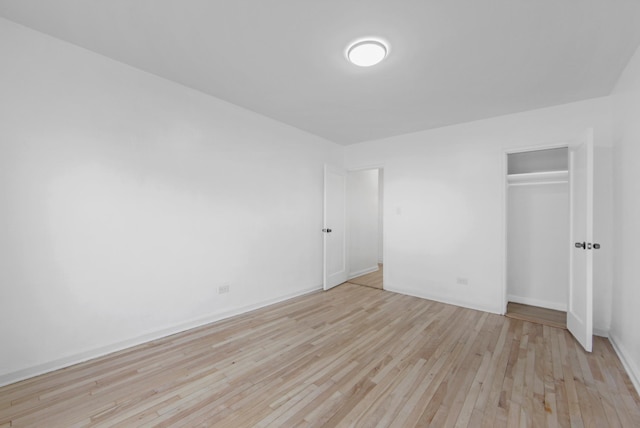 unfurnished bedroom with a closet and light wood finished floors