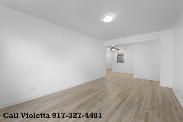 unfurnished room featuring light wood-type flooring, a ceiling fan, and baseboards