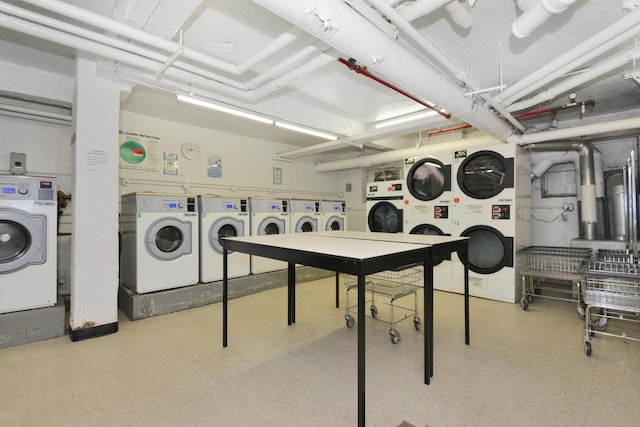 common laundry area with washing machine and dryer, stacked washer and clothes dryer, and light floors