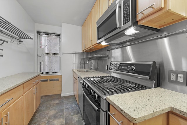 kitchen featuring tasteful backsplash, light stone counters, stainless steel appliances, light brown cabinets, and a sink