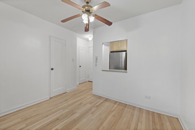 empty room with light wood-type flooring, ceiling fan, and baseboards