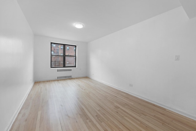 34-40 78th St Unit 4H, New York City, NY 11372 - spare room with radiator, light wood-style flooring, and baseboards