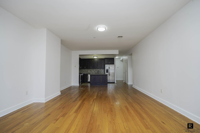 unfurnished living room with baseboards, wood finished floors, and visible vents