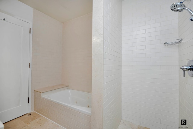 bathroom with a jetted tub and tiled shower
