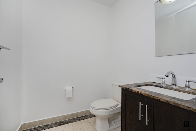 half bath with vanity, baseboards, and toilet