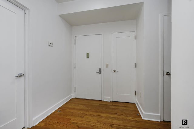 interior space featuring baseboards and wood finished floors