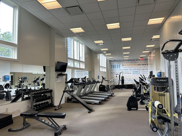 gym featuring visible vents, a paneled ceiling, and a wealth of natural light