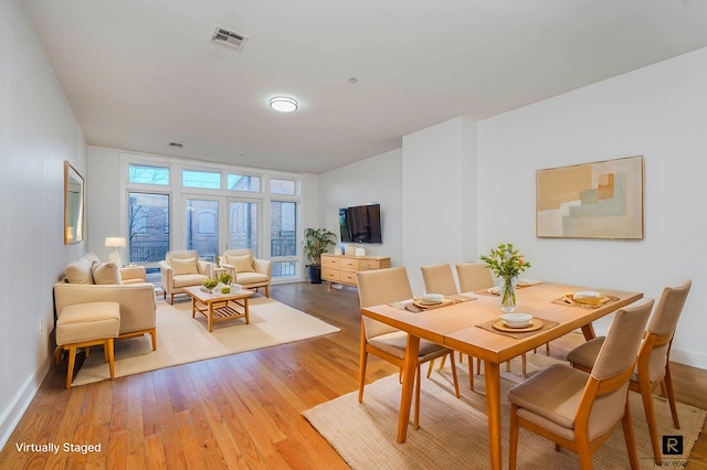 dining area featuring baseboards, visible vents, and light wood-type flooring