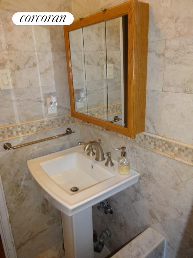 bathroom featuring backsplash and tile walls