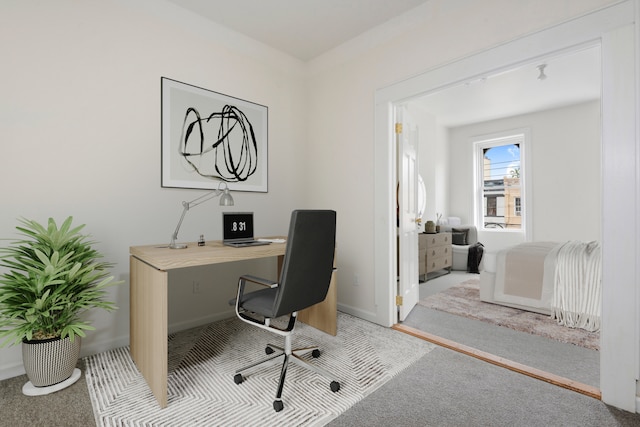 carpeted office space featuring baseboards