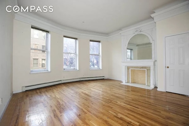 unfurnished living room with crown molding, a premium fireplace, baseboard heating, and wood finished floors