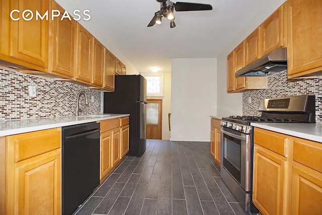 kitchen featuring dark wood-style floors, under cabinet range hood, light countertops, black appliances, and a sink