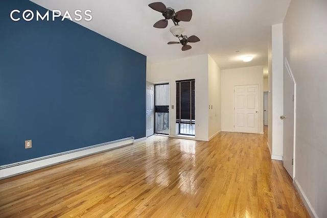 unfurnished living room with ceiling fan, baseboards, baseboard heating, and wood finished floors