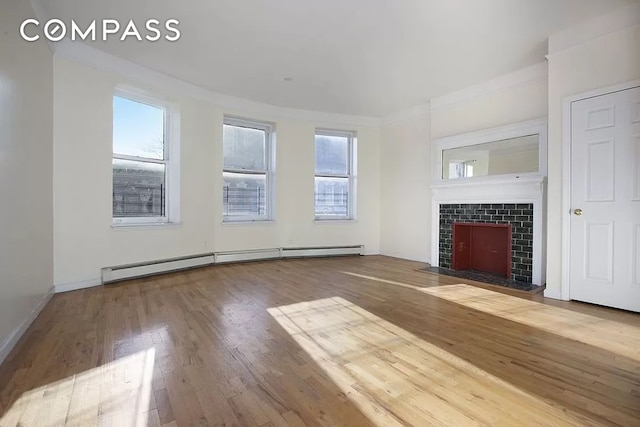 unfurnished living room with hardwood / wood-style flooring, a baseboard radiator, baseboards, and a tiled fireplace