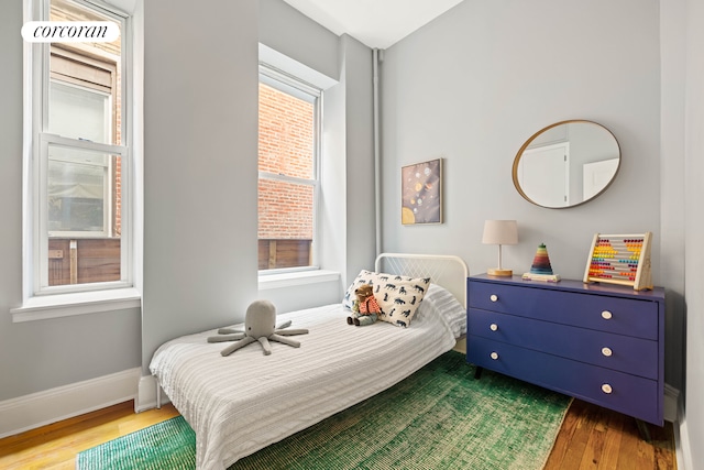 bedroom featuring wood finished floors and baseboards