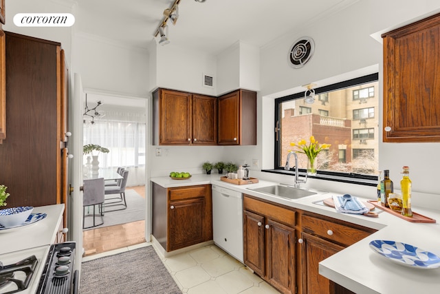 kitchen with white dishwasher, stove, light countertops, and a sink
