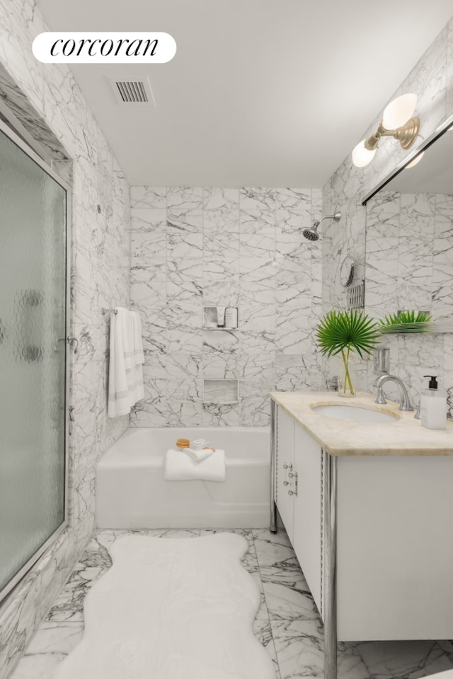 full bath featuring vanity, a shower with door, a bathtub, marble finish floor, and visible vents