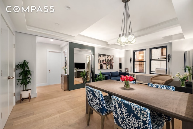 dining room with light wood-type flooring, a tray ceiling, recessed lighting, and baseboards