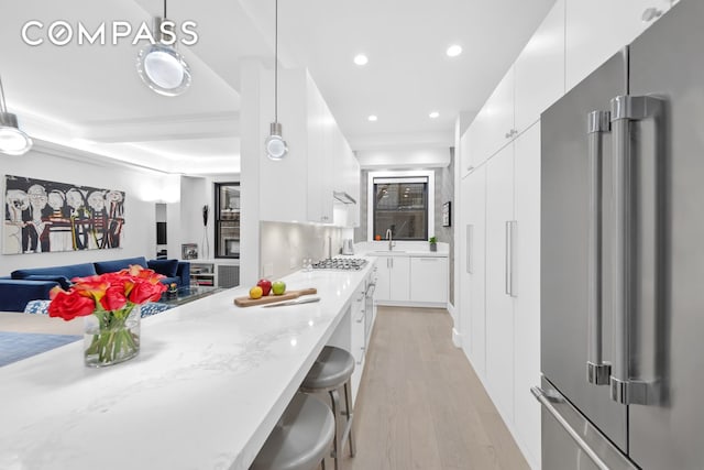 kitchen featuring light wood-type flooring, modern cabinets, recessed lighting, stainless steel appliances, and white cabinets