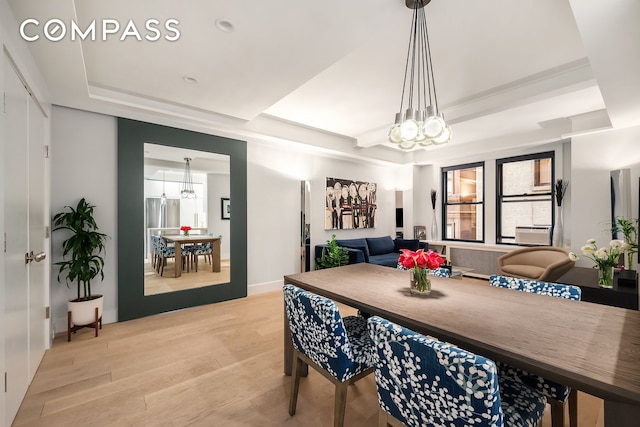 dining room with a chandelier, light wood-style floors, a tray ceiling, and recessed lighting