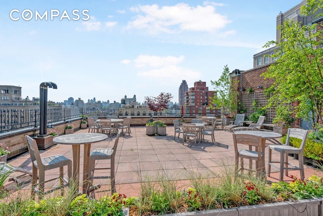 view of patio with outdoor dining space, a view of skyline, and fence