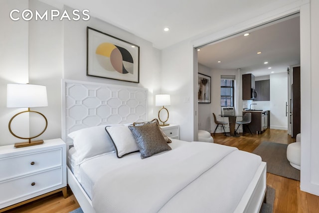 bedroom with recessed lighting, cooling unit, and wood finished floors