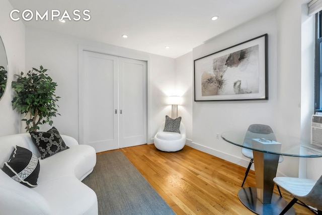 living area with baseboards, light wood finished floors, and recessed lighting