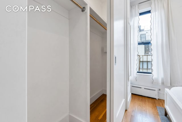 bathroom featuring wood finished floors and a baseboard radiator