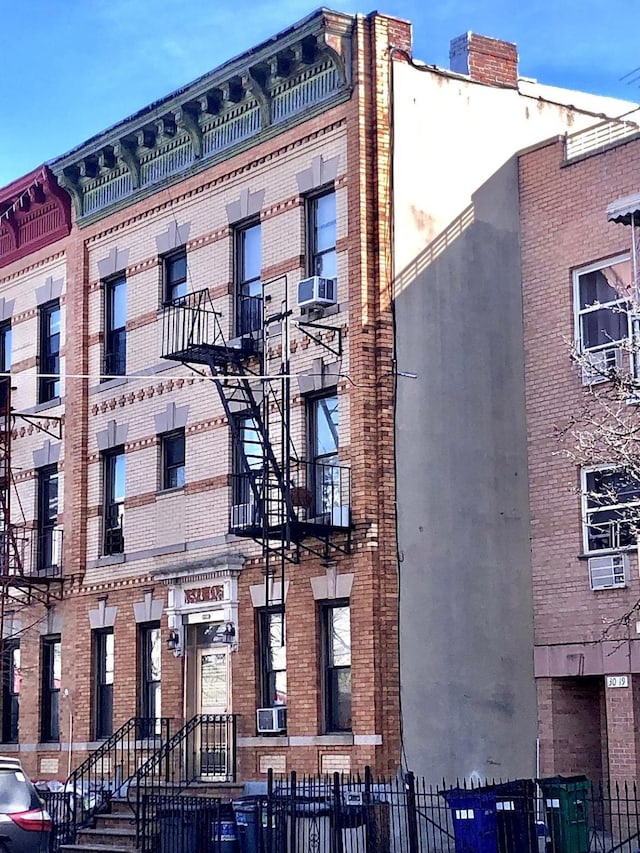 view of building exterior with fence and cooling unit