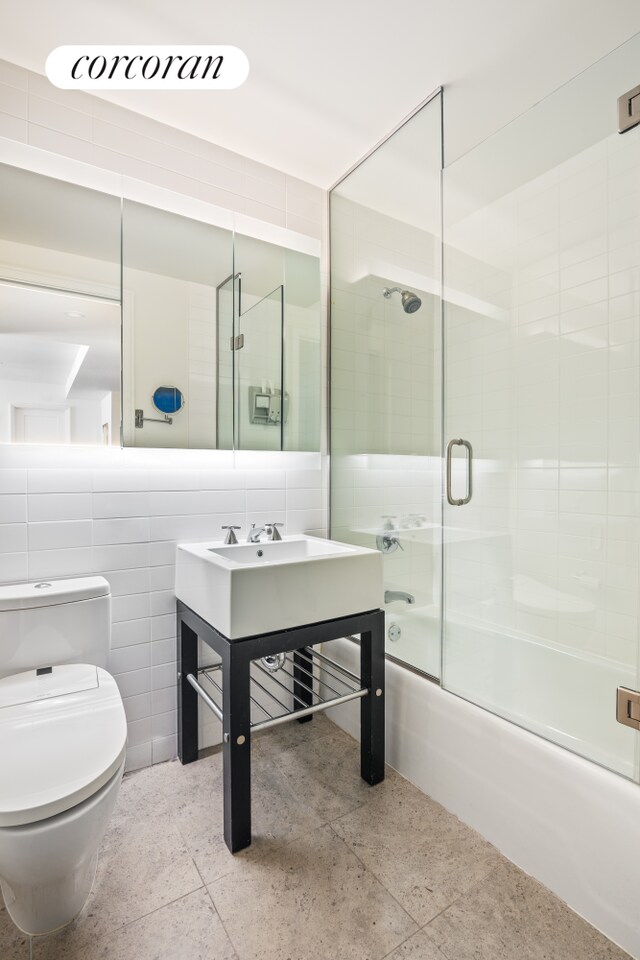 70 Little W St Unit 22G, New York City, NY 10280 - bathroom with toilet, combined bath / shower with glass door, vanity, and tile walls